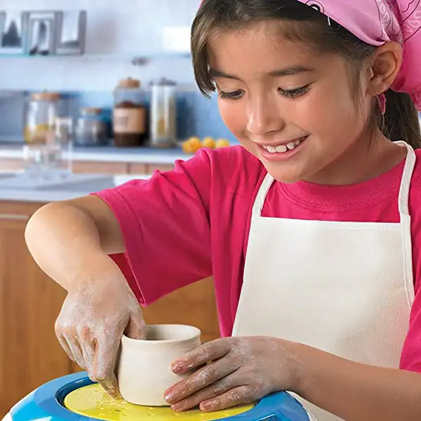 Egy kislány használja a kézműves készletet.